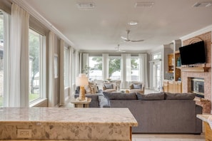 A spacious living room with a fireplace, a television, and a large window.