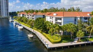 A waterfront hotel with multiple-story buildings, a dock with boats, and a well-maintained garden with palm trees. - Walk to Las Olas + 15 Min to Beach + Sleeps 6 (Fort Lauderdale)