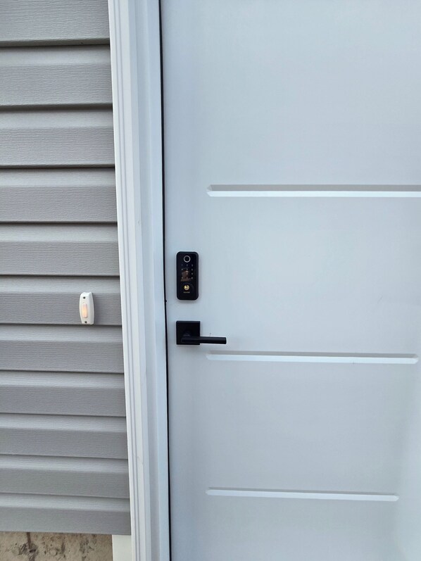 Puerta blanca con cerradura electrónica y manija.