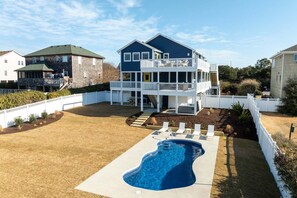 A two-story house with a backyard swimming pool, a covered patio, and a fenced yard. - KH112 Sound Decision by First Flight Rentals (Kitty Hawk)