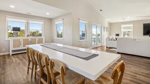 Un amplio espacio de estar con una mesa de comedor, sillas, un sofá y un televisor.