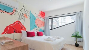A modern hotel room with a large bed, a bedside table, a potted plant, and a window with curtains. - MOT Rentals + Guatemala D - 2 Bd in Palermo Soho (Buenos Aires)