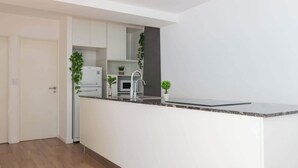 A modern kitchen with white cabinetry, a granite countertop, and stainless steel appliances. - MOT Rentals + Guatemala D - 2 Bd in Palermo Soho (Buenos Aires)
