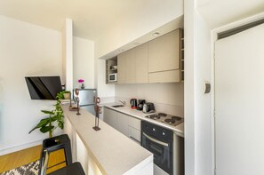 Eine moderne Küche mit Flachbildfernseher, Kaffeemaschine und Mikrowelle.