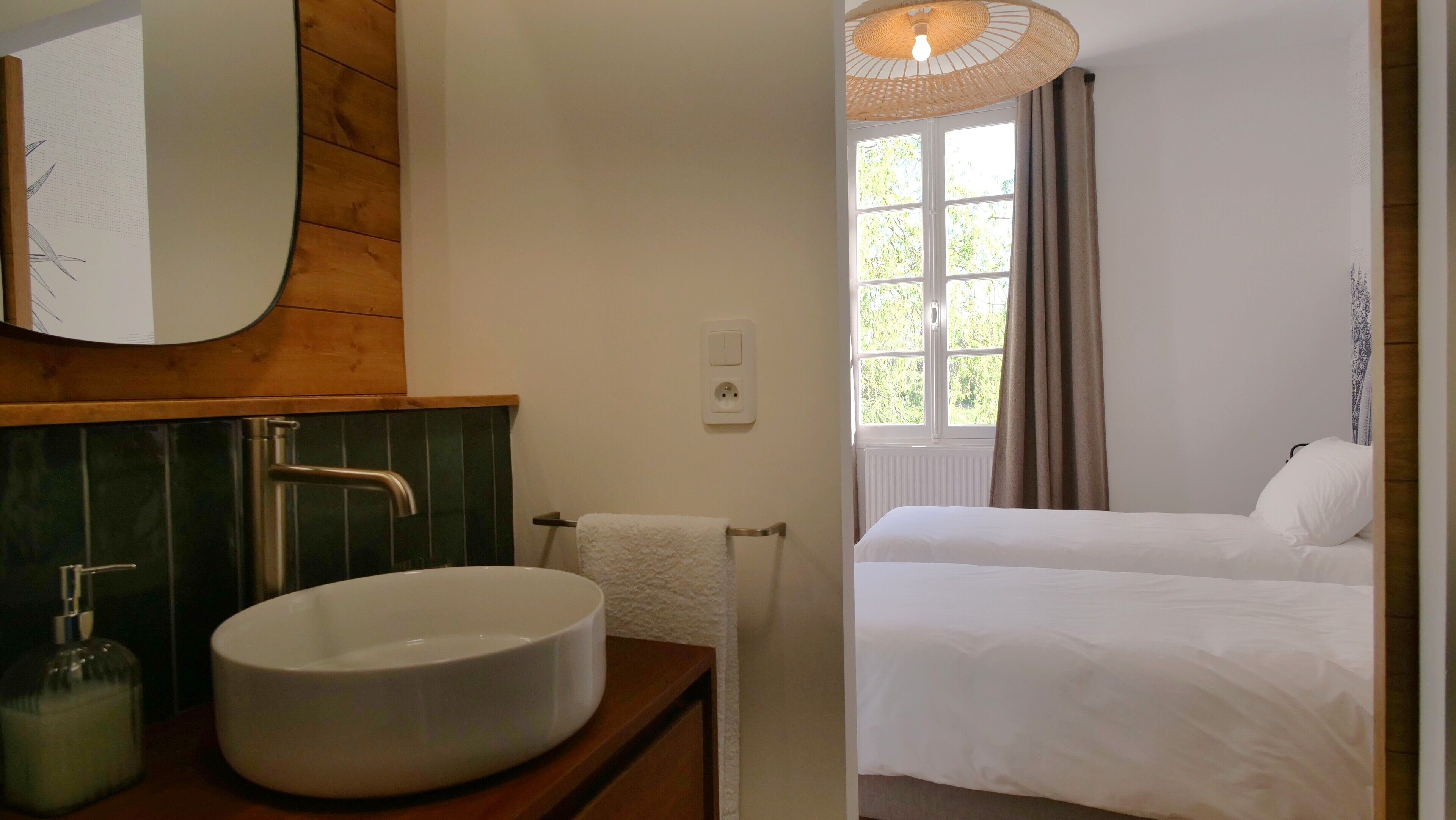 A bathroom with a large sink, a mirror, and a towel rack.