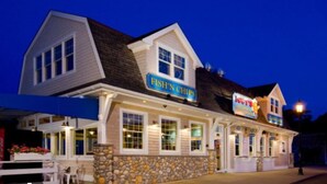 Un edificio de dos pisos con un letrero que dice 'Fish'n Chips' y 'Lucy's'.