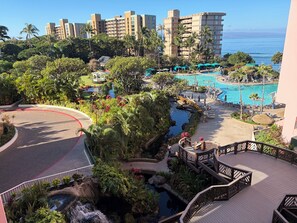 Et resort med pool, frodigt grønt område og udsigt over havet.