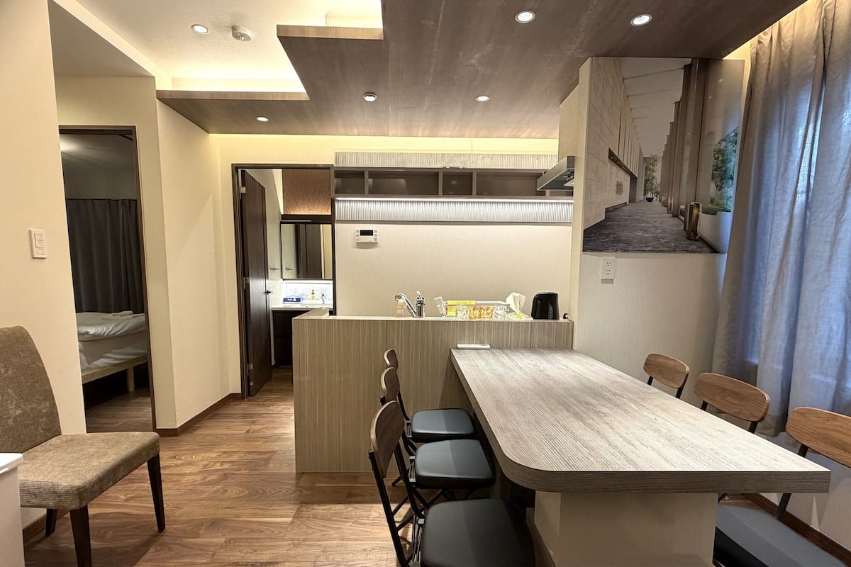 Una cucina moderna con isola centrale, sgabelli da bar e un tavolo da pranzo.