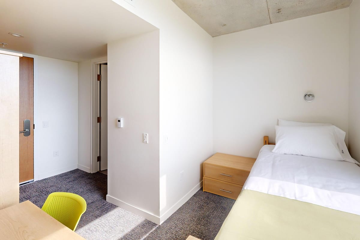 Ein Schlafzimmer mit Bett, Nachttisch und Stuhl.