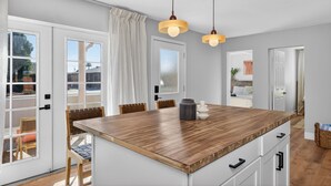 A kitchen with a central island, white cabinetry, and pendant lighting. - Stylish 6BR Home, Pool, Sleeps 12,Near Old Town (Scottsdale)