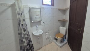 Ein Badezimmer mit Toilette, Waschbecken und Duschvorhang.
