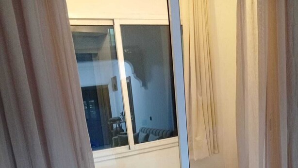 A hotel room with a bed, a sofa, and a view of the outside through a large window. - Accommodation marrakech guéliz (Marrakech)
