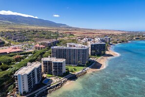 A coastal resort with high-rise buildings, a beach, and a mountainous backdrop. - New Listing Ocean View Top-Floor Corner Unit W/ Beach Access At Kahana Villas (West Maui) (Lahaina)