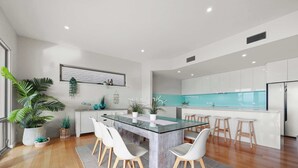 A modern kitchen with a central island, white cabinetry, and a large window.