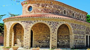 A historic stone building with a circular design, arched windows, and a cross on top. - Holiday Apartment Sea of Juniper Two-Room Apartment (Badesi)