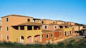 Filera d'edificis uniformes de dues plantes amb terrasses planes i un estil arquitectònic coherent.