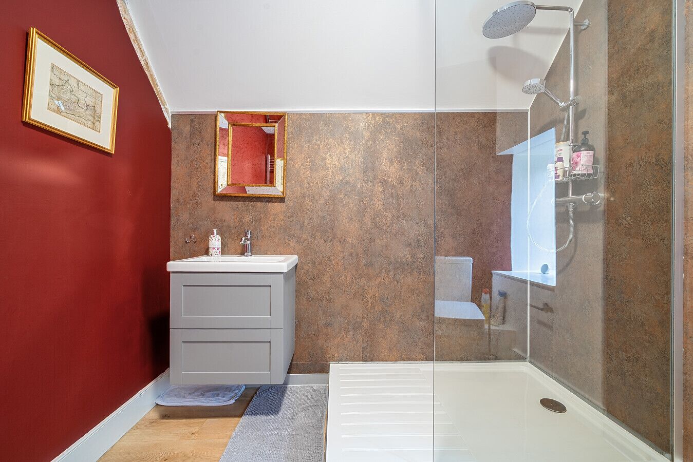 Ein Badezimmer mit Dusche, Waschbecken und Spiegel.