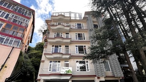 A multi-story building with balconies, a sign for 'The Croft' hotel, and a parking area. - The Croft Bnb (Shimla)