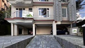 A building with a sign reading "The Croft" and a parking area with cars. - The Croft Bnb (Shimla)