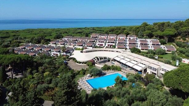 A resort with multiple buildings, a large swimming pool, and a view of the sea. - Holiday flat studio apartment with air conditioning (Castiglione della Pescaia)