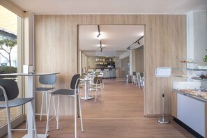 Ein modernes Café mit Holzwänden, einem zentralen Servicebereich und verschiedenen Sitzgelegenheiten.