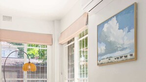 Een moderne kamer met een houten bureau, een groene fauteuil en een schilderij van een landschap.