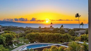 A resort with a swimming pool, lush greenery, and a sunset view over the ocean. - 2 2 Luxurious Wailea Oceanview Resort Vistas (Wailea-Makena)