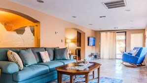 A living room with a blue sofa, a wooden coffee table, and a blue rocking chair. - A tranquil place to relax (Scottsdale)