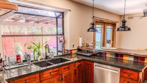 A kitchen with wooden cabinets, a stainless steel dishwasher, and a granite countertop. - A tranquil place to relax (Scottsdale)