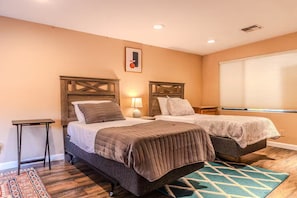A bedroom with two beds, a small table, a lamp, and a window with blinds. - A tranquil place to relax (Scottsdale)