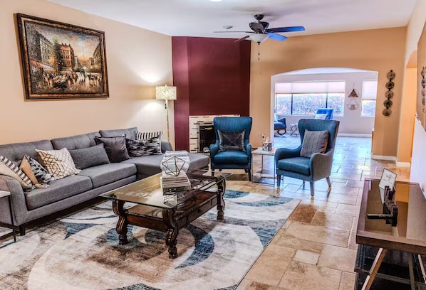 A living room with a sofa, armchairs, a coffee table, and a painting on the wall. - A tranquil place to relax (Scottsdale)