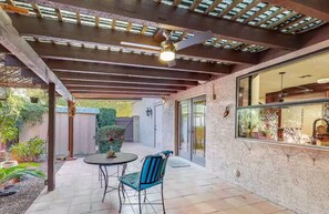 A covered patio with a table and chairs, a ceiling fan, and a view of the backyard. - A tranquil place to relax (Scottsdale)