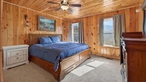 A wooden-paneled bedroom with a bed, a nightstand, a dresser, and a ceiling fan. - The Nantahala Dollhouse
Cozy 3-bedroom rustic cottage in the heart of Nantahala (Topton)