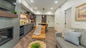 Uma sala de estar moderna com lareira, um sofá e um espaço de jantar com mesa e cadeiras.