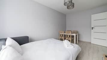 Tabla de planchar con plancha y ropa de cama