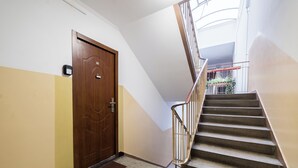 Una scala con corrimano in legno e una porta con una targa identificativa.