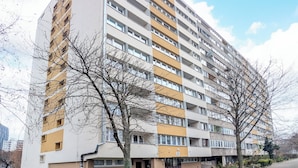 Edifício residencial de vários andares com telhado plano e fachada uniforme.