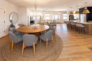 Een moderne keuken met een centraal kookeiland, barkrukken en hanglampen.