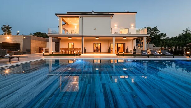 Ein modernes, zweistöckiges Haus mit Pool.