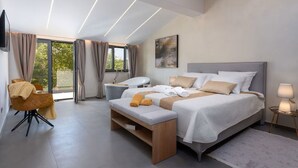 Ein modernes Schlafzimmer mit einem großen Bett, einer Bank, einem Stuhl, einem Schminktisch und einem Fernseher.