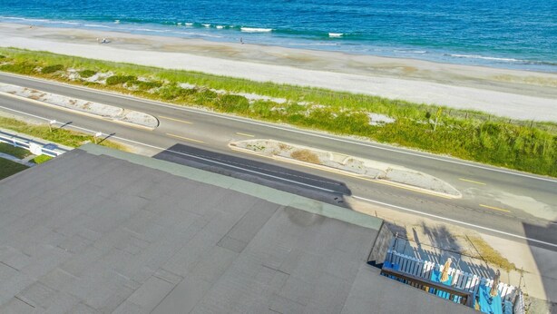 Una carretera costera con una playa y el océano al fondo.
