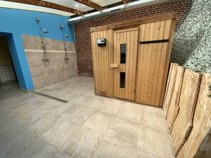 A wooden sauna with a tiled floor and a blue wall.