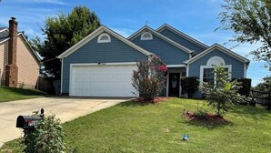 A two-story house with a garage, a well-maintained lawn, and a mailbox. - Grill Patio • Pet Friendly • 3BR (Charlotte)