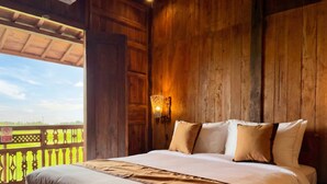 Una habitación de madera con una cama, una mesita de noche y una lámpara de pared.