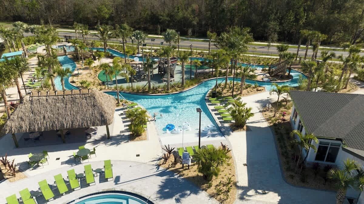 A resort with multiple swimming pools, lounge areas, and palm trees.