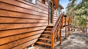 Une cabane en bois avec un escalier en bois menant à une terrasse.