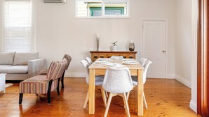 Een eethoek met een houten tafel voor vier personen, omringd door gestreepte stoelen.