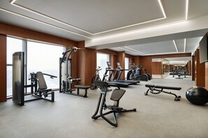 A modern gym with various exercise equipment, large windows, and a spacious layout. - Taj Palace, Lucknow (Lucknow)