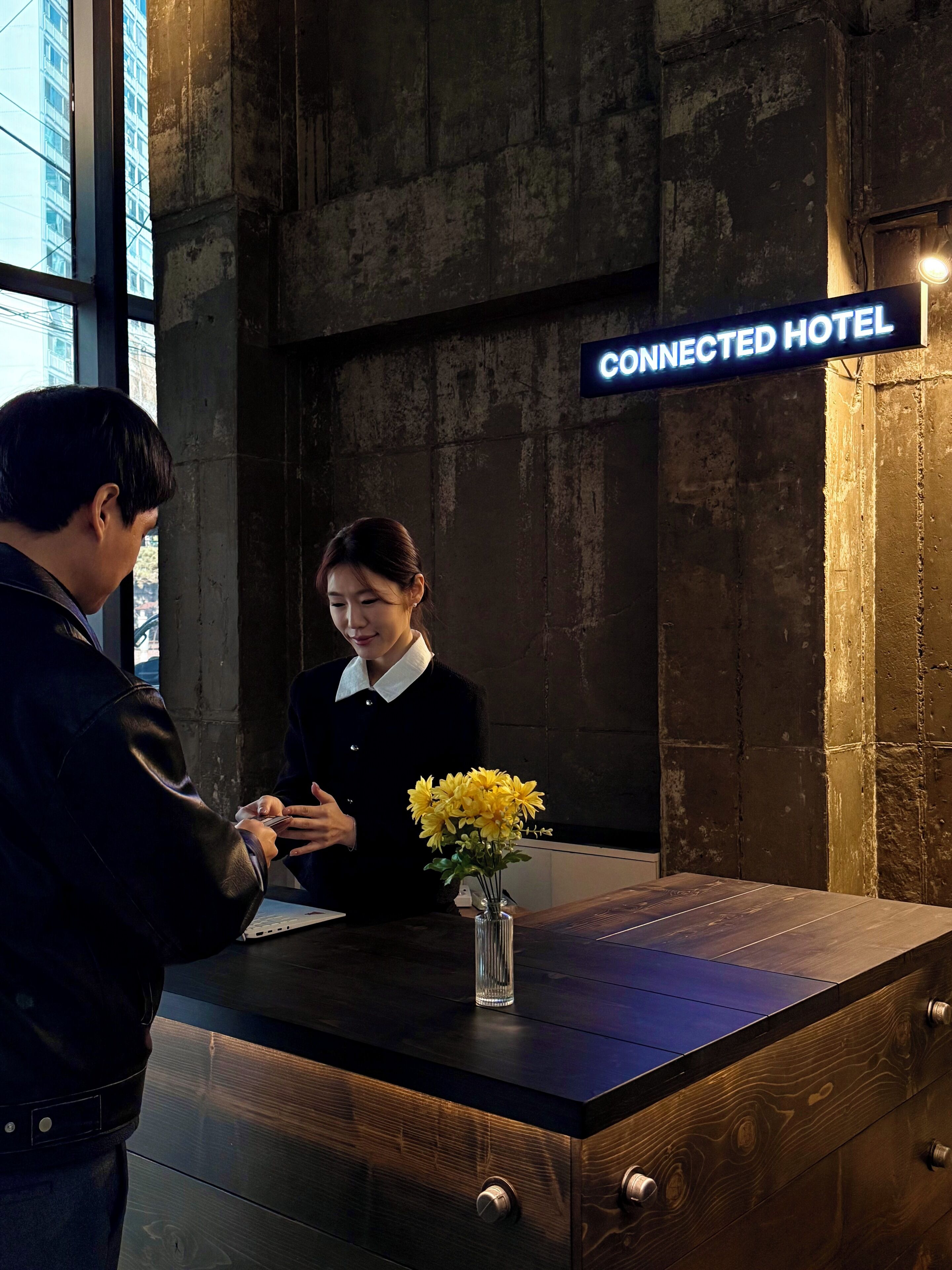 A reception desk at a hotel with a sign that reads "CONNECTED HOTEL".