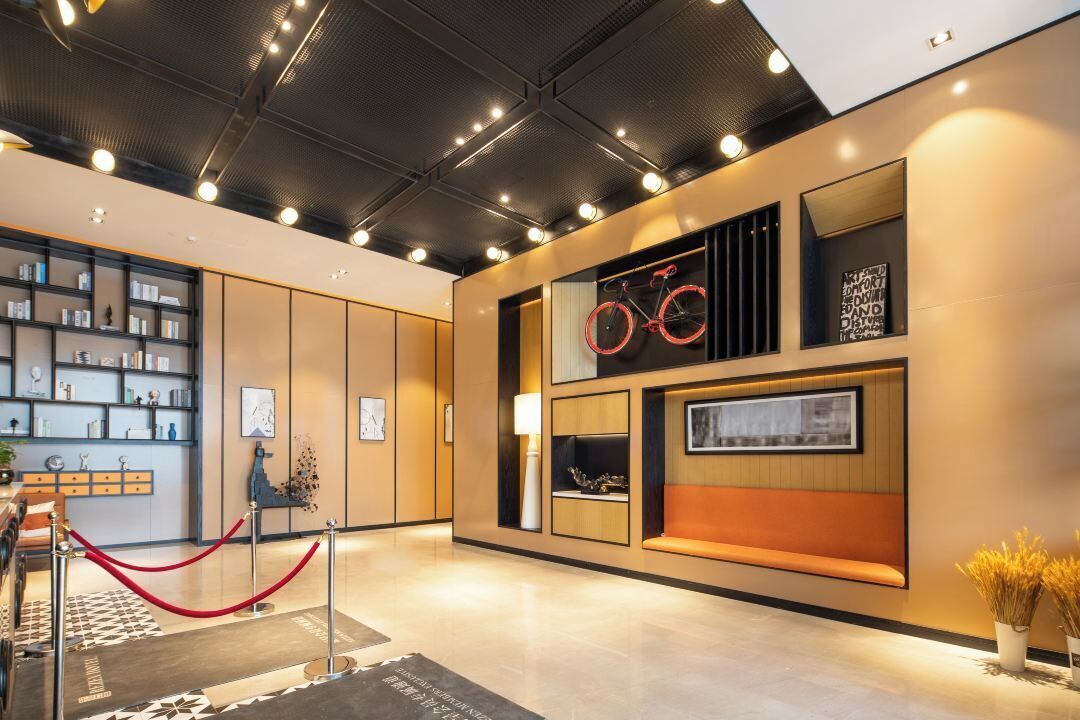 A modern lobby with a seating area, a bookshelf, and a bicycle-themed wall decoration.